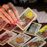 woman's hand holding tarot cards
